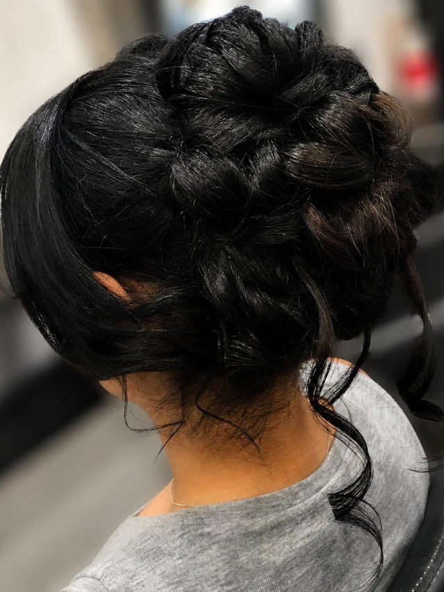 Braided black upstyle with soft face-framing tendrils
