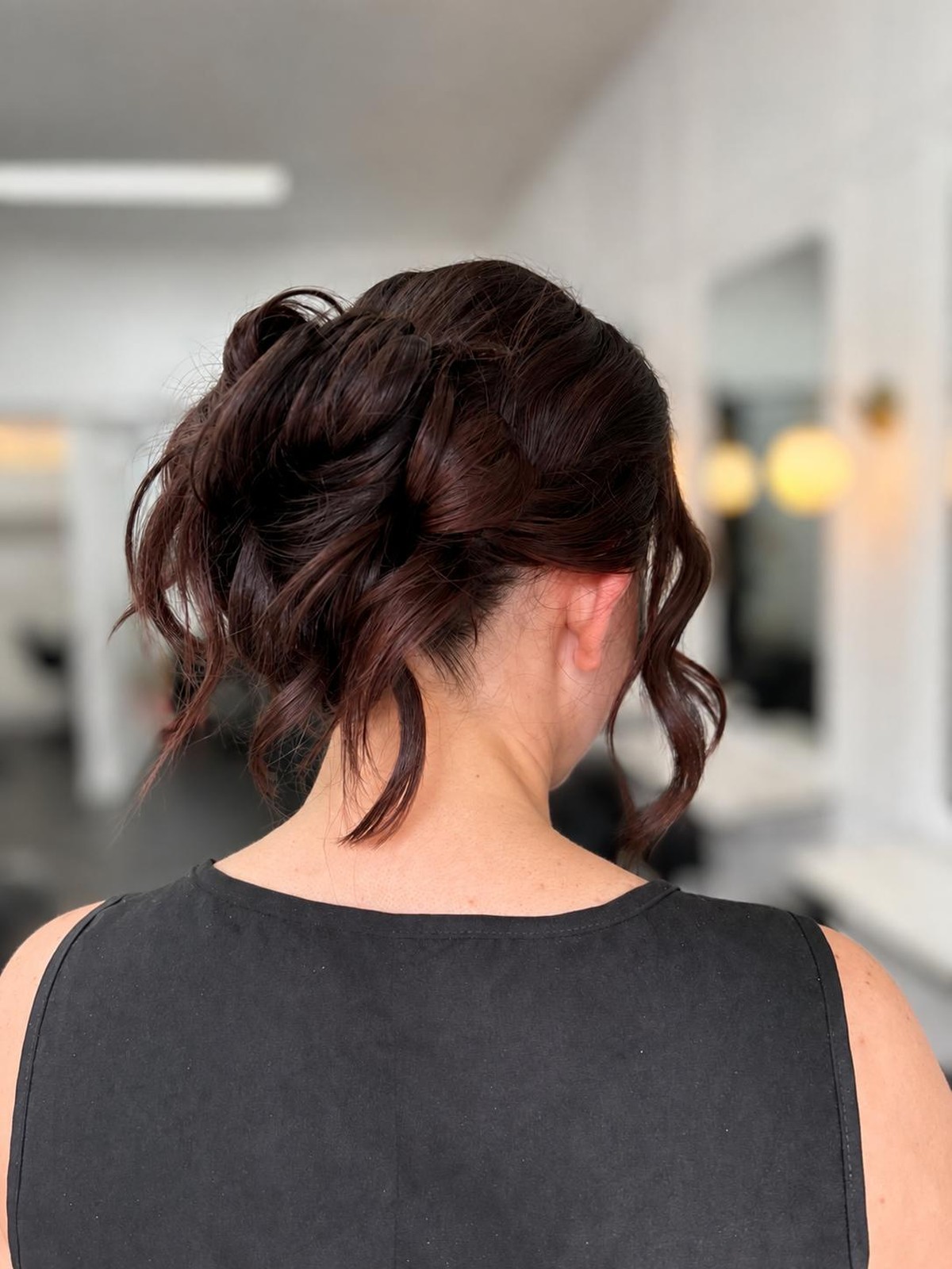 Dark brunette textured updo with soft tendrils, back view